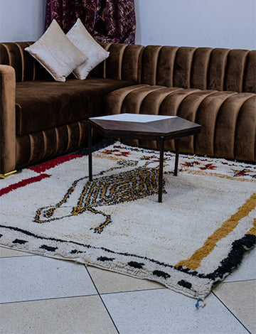 White Moroccan rug with vibrant Berber colors and a lizard design enhancing a living room decor.