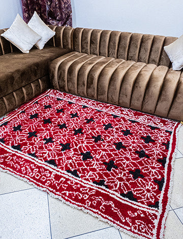 Vibrant red Moroccan rug with striking plus symbol pattern enhancing a living room decor.
